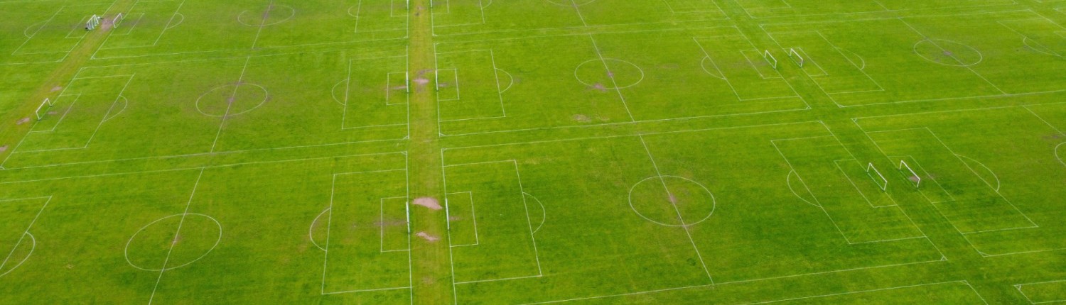 An aerial shot of multiple grass football pitches side-by-side